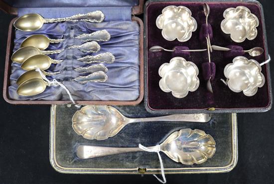 A set of four shaped silver salts and spoons, a pair of silver preserve spoons and a set of six silver coffee spoons, all cased